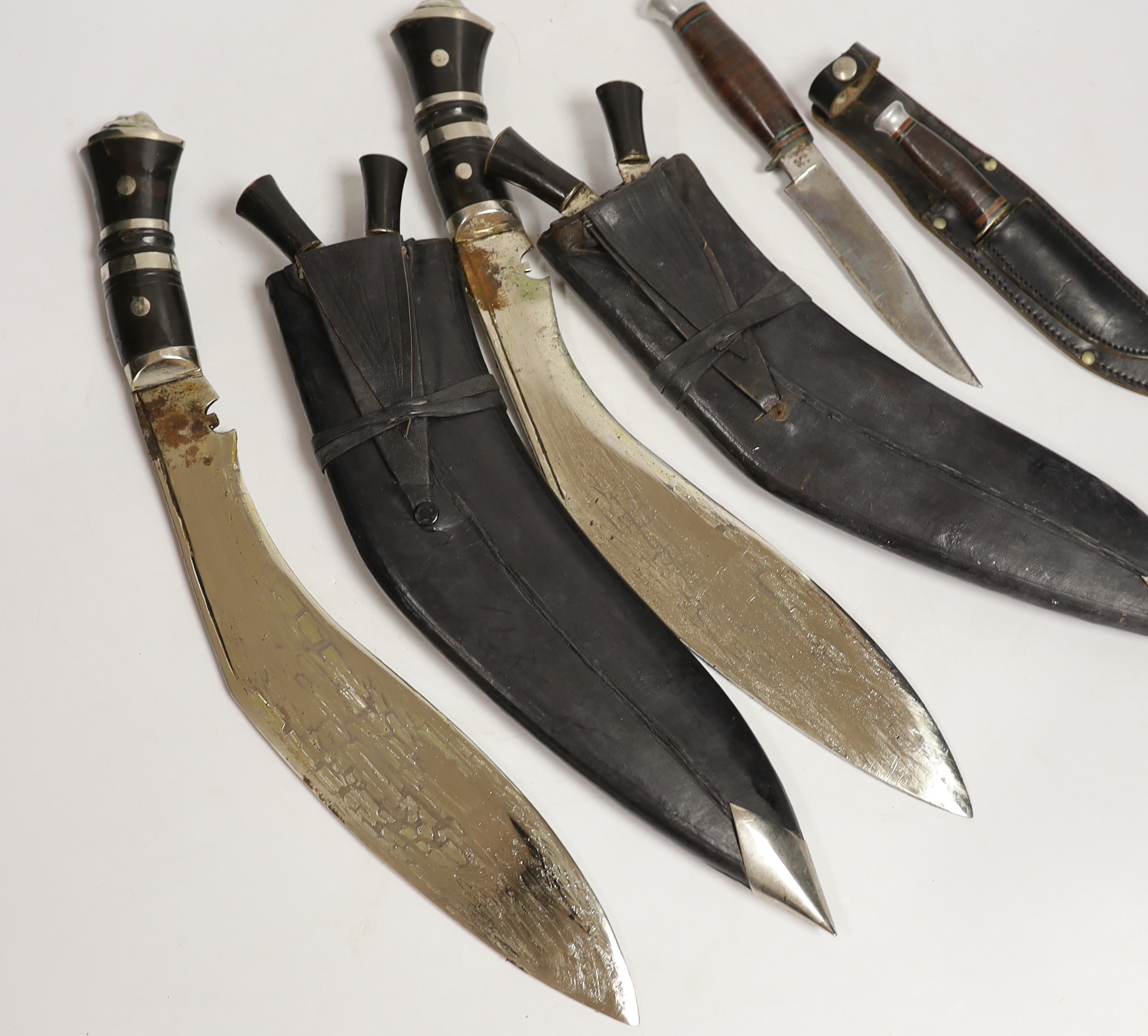 Two large kukris and a smaller similar kukri